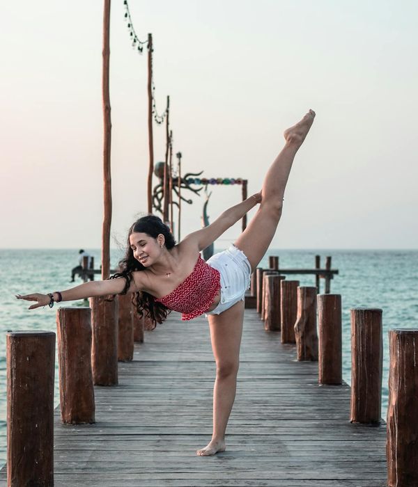 Person stretching gently outdoors with a smile.